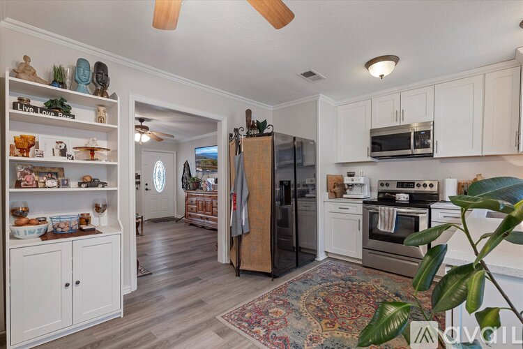 A kitchen with white cabinets and a rug on the floor.