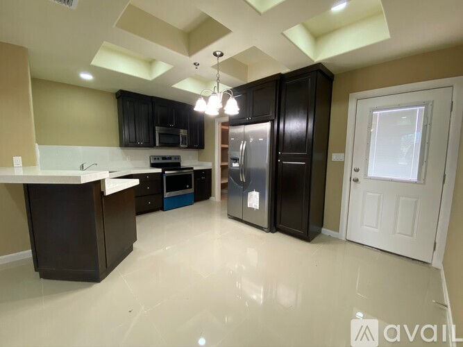 A kitchen with black cabinets and a white countertop is available.