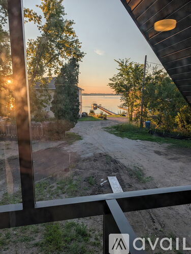 A view from a window looking out to a sandy path and trees.