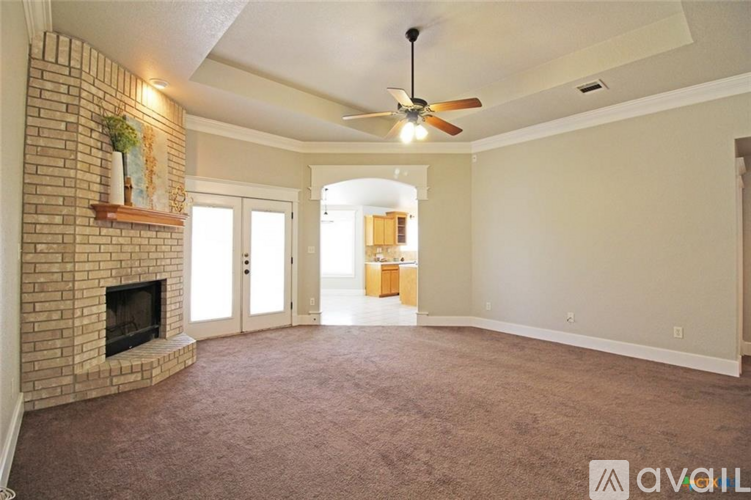 A living room with a fireplace and a ceiling fan.