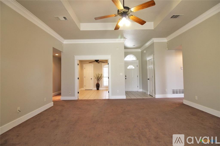A spacious room with a ceiling fan and carpeted floor.