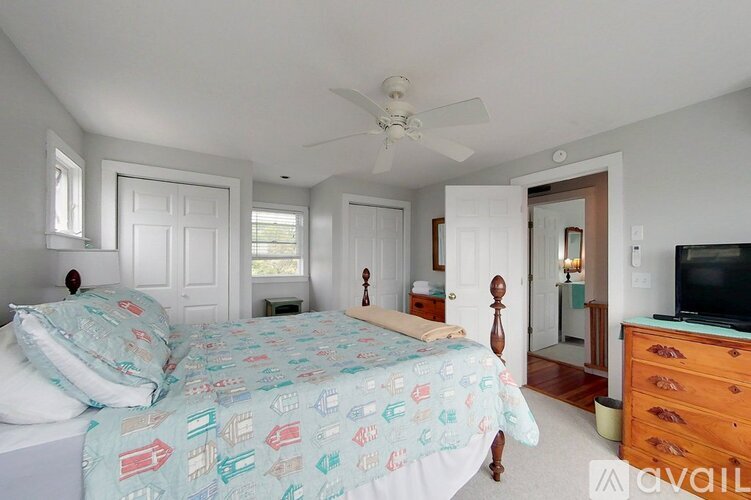 A bedroom with two beds and a television.