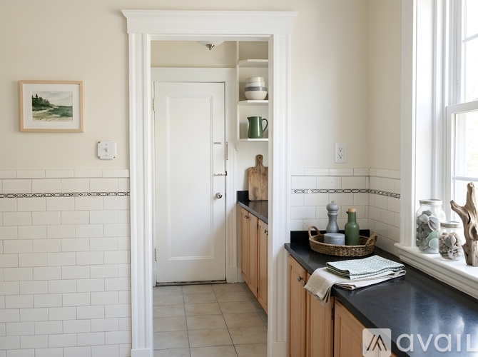 A kitchen with white walls and a white door.