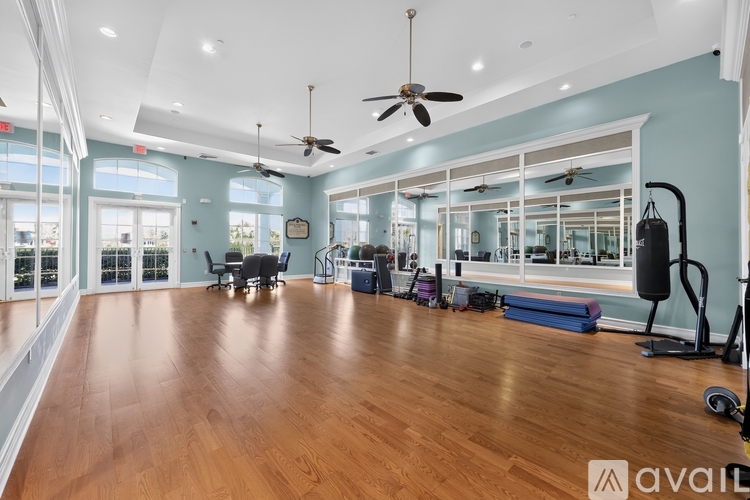 A spacious room with wooden floors and exercise equipment.