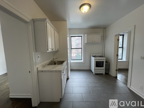 A kitchen with white cabinets and a marble countertop.