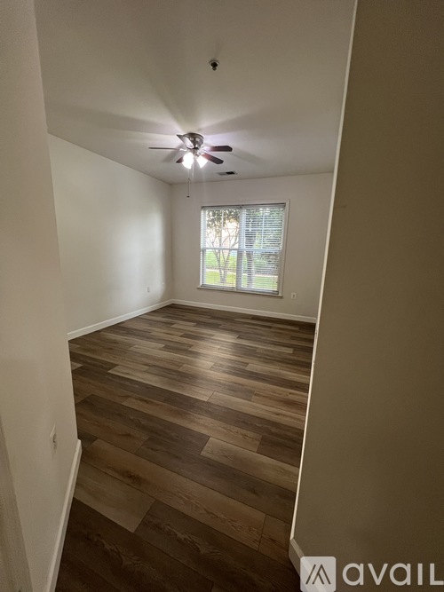 A room with wooden flooring and a ceiling fan.