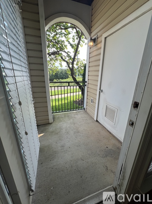A patio area with a white door and a white wall.