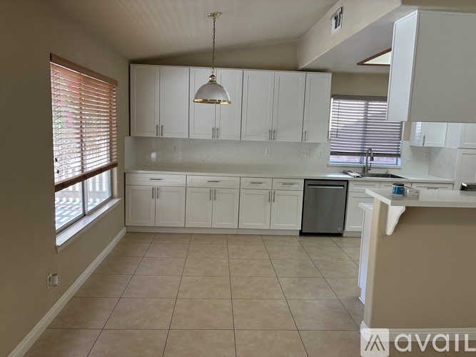 A kitchen with white cabinets and a dishwasher.