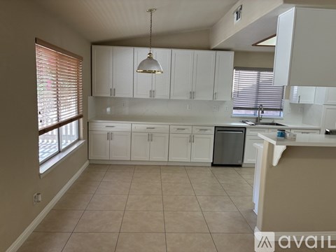 A kitchen with white cabinets and a dishwasher.