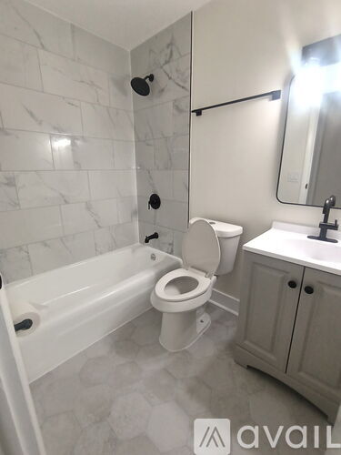 A white toilet in a bathroom with a marble wall.