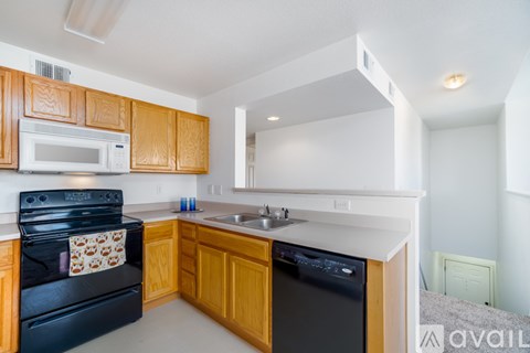 A kitchen with wooden cabinets and black appliances.