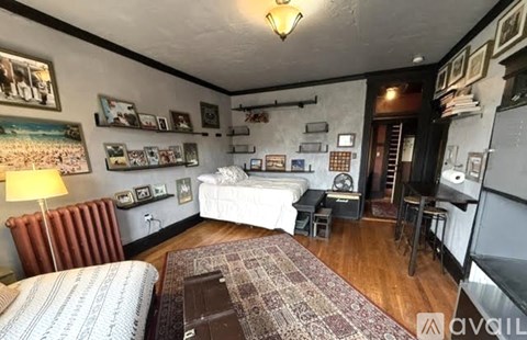 A living room with a couch, a bed, and a table.