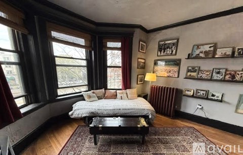 A bedroom with a large bed and a window overlooking a city.