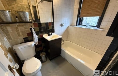A bathroom with a white toilet, a white sink, and a white bathtub.