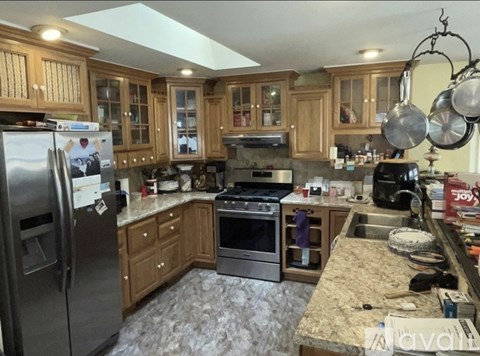 A kitchen with wooden cabinets and granite countertops.