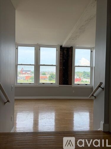 A room with a large window and wooden flooring.