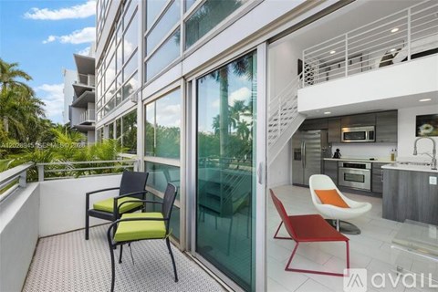 A balcony with chairs and a kitchen area.