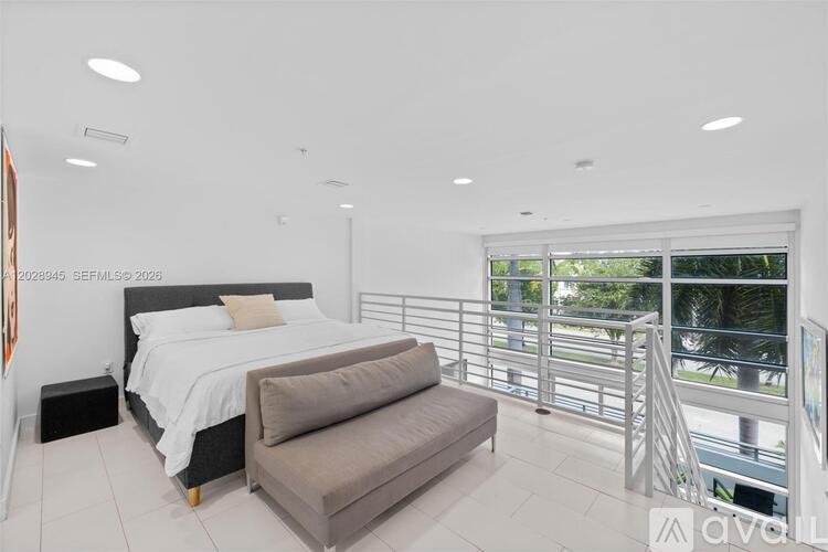 A bedroom with a large bed and a balcony.