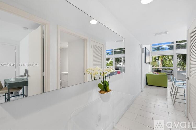 A bright, white interior space with a long white table and chairs.