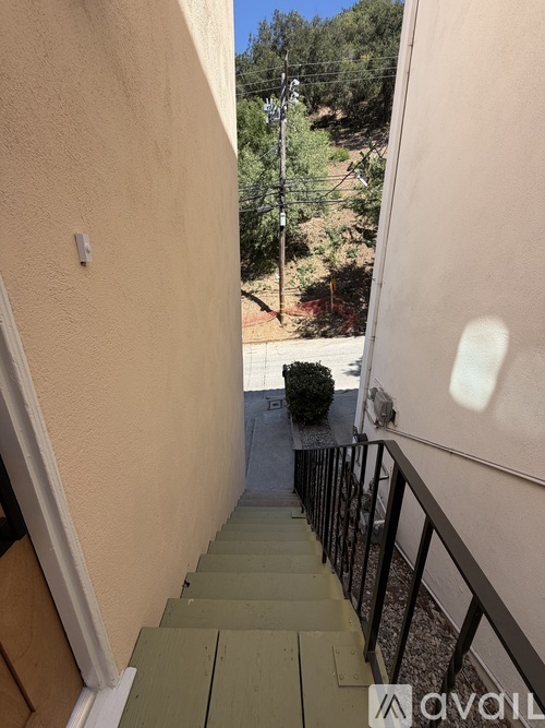 A narrow staircase with a metal railing leads to a balcony.