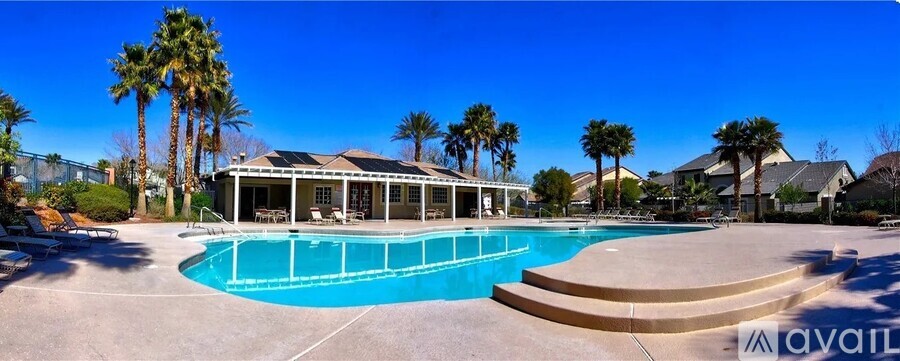 A pool surrounded by palm trees and a pavilion.