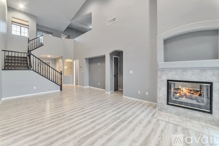A modern living room with a fireplace and a staircase.