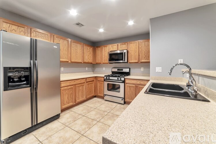 A kitchen with wooden cabinets and a stainless steel refrigerator.