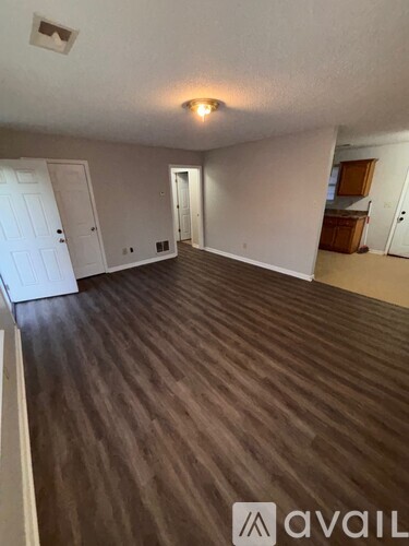 A room with wooden flooring and white walls.