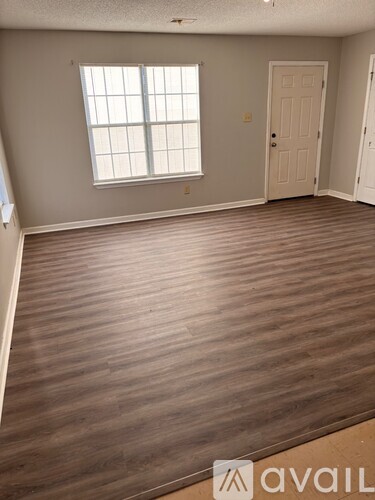 A room with wooden flooring and a window.