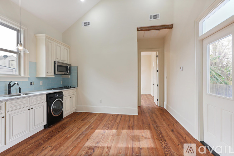 A kitchen with wooden floors and white walls.
