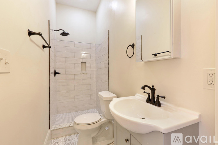 A white sink with a black faucet is on a countertop in a bathroom.