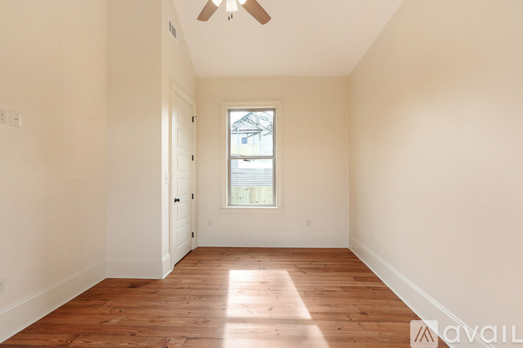 A room with wooden floors and a window letting in light.