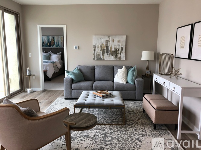 A living room with a grey couch, a brown chair, and a coffee table.