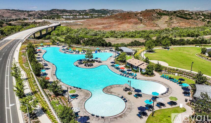A large outdoor swimming pool with a winding design and several lounge chairs.