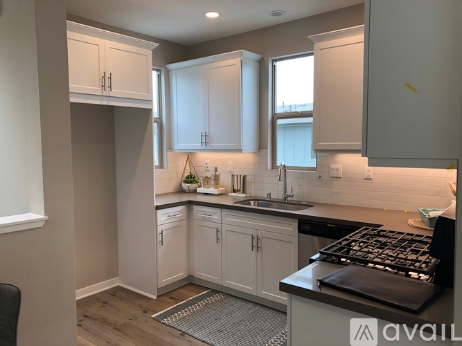 A kitchen with white cabinets and a black stove top.