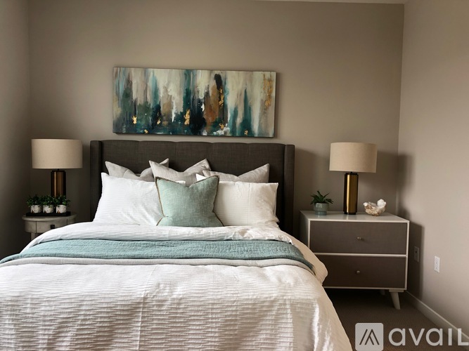 A bedroom with a large bed and a painting above it.
