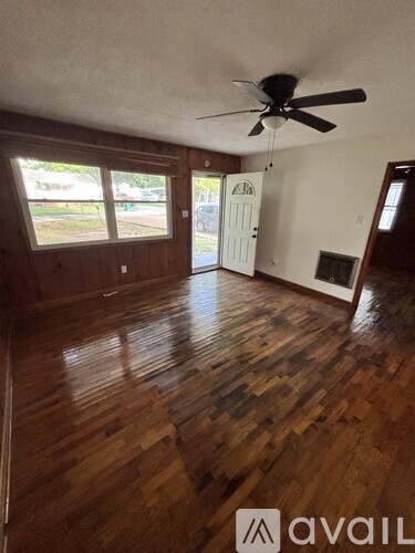 A room with wooden floors and a ceiling fan.