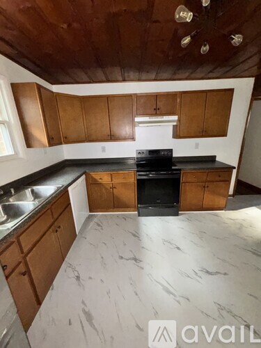 A kitchen with wooden cabinets and a black stove top oven.