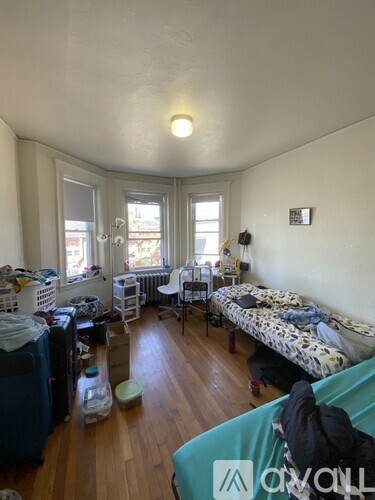 A room with a bed, a chair, and a table.