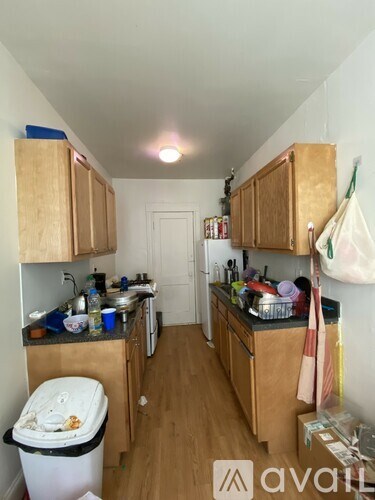 A kitchen with wooden cabinets and a white door in the background.
