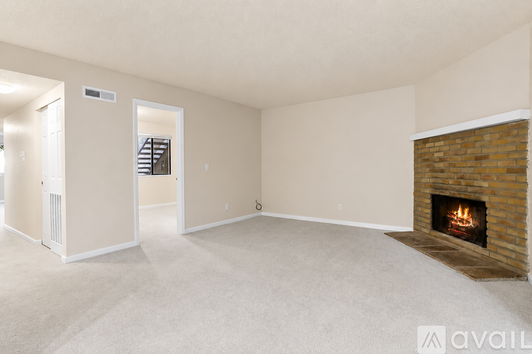 A living room with a fireplace and a carpeted floor.
