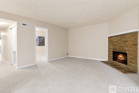 A living room with a fireplace and a carpeted floor.