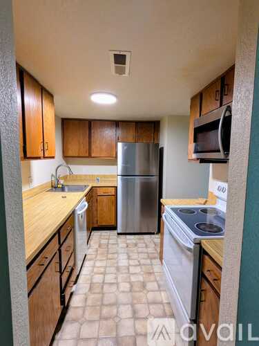 A kitchen with a refrigerator, stove, and microwave.