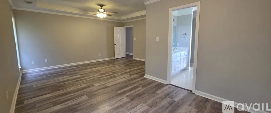 A room with wood flooring and a ceiling fan.
