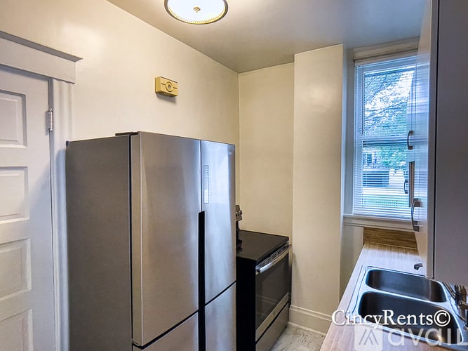 A kitchen with a stainless steel refrigerator and a black oven.