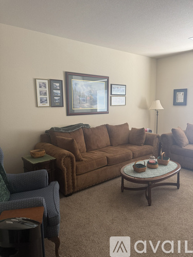 A living room with a brown couch, a blue chair, and a coffee table.