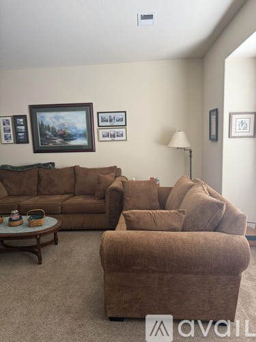 A living room with a brown couch and a coffee table.