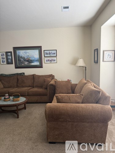 A living room with a brown couch and a coffee table.