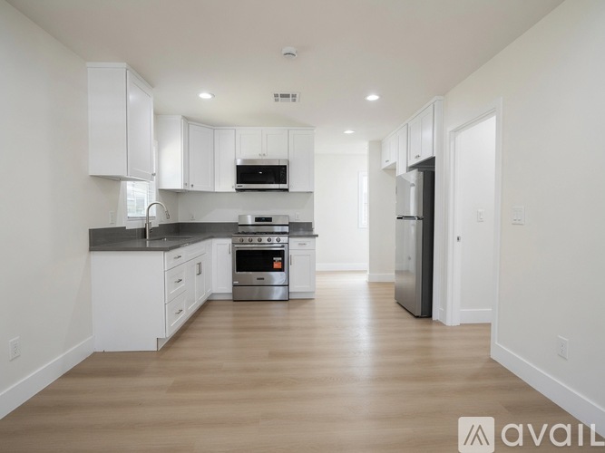 A modern kitchen with white cabinets and stainless steel appliances.