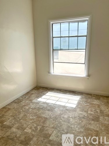 A room with a window and tiled flooring.